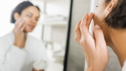 Woman applying cream on her face